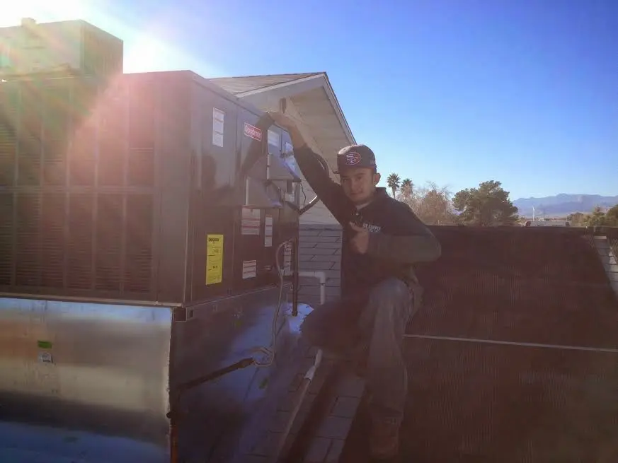 HVAC technician performing Air Duct Cleaning on a rooftop unit in Frankfort